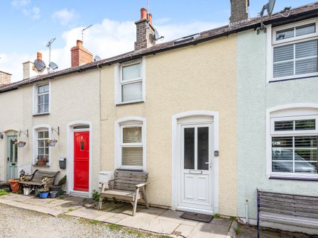 A row of terraced houses with benches and potted plants outside at Fishermans Cottage in Conwy