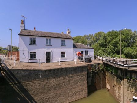 A house by a dock with a life buoy and bridge at The Lock House in Gloucester
