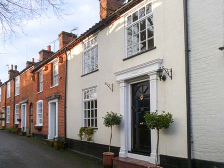 A row of terraced houses with front doors and windows along a street at Teds Place in Aylsham