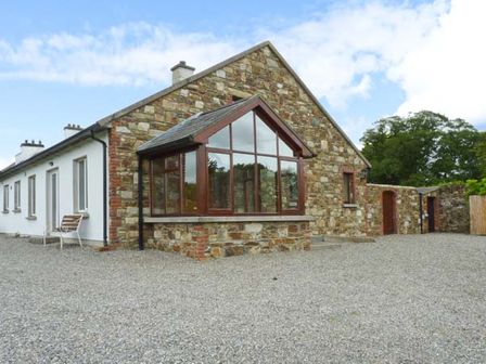 A stone and white exterior house with large windows and gravel driveway at The Range in Enniscorthy County Wexford