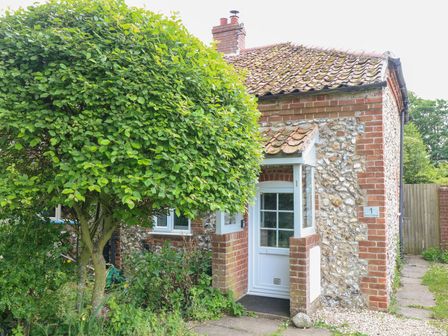 A cottage exterior with a tree and a pathway at Broom Cottage in East Rudham near Fakenham