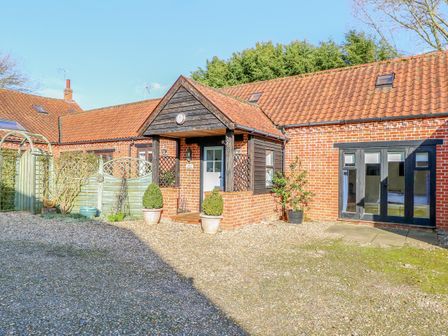 A gravel driveway leading to a brick house with a tiled roof and a covered porch at Stable Cottage Necton near Swaffham