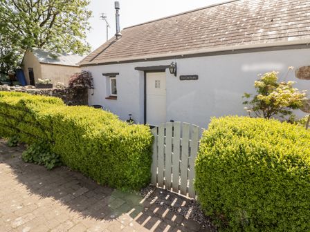 Front of a white cottage with a small gate and trimmed hedges at The Old Stable in Wolfscastle near Haverfordwest