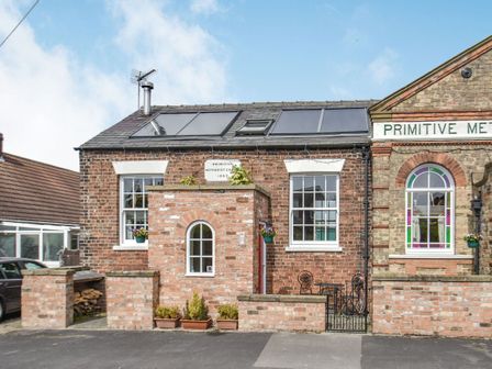 A brick building with windows and solar panels on the roof at The Old Chapel in Hornsea