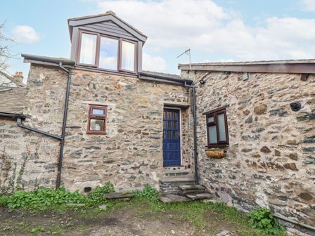 An entrance with stone walls and steps at Dovetail Cottage in Llangollen