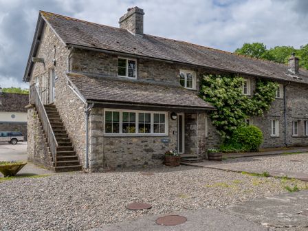 Stone house with external staircase and gravel driveway at Crabtree in Hawkshead