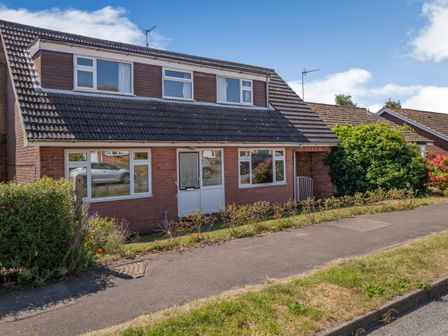 A brick house with tiled roof and white framed windows behind a sidewalk at 38 Dale End in Brancaster Staithe near Burnham Market