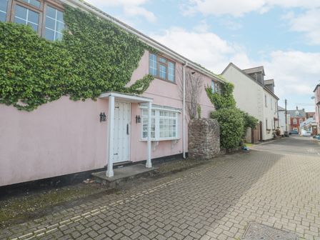 A street view of a house with a pink exterior partially covered with ivy at The Cottage in Watchet