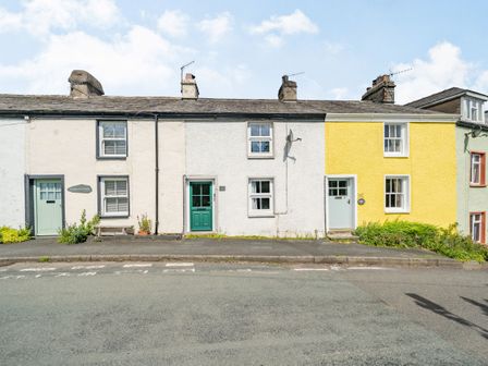 A row of small terraced houses with different colored doors and walls along a street at No 7 Spark Bridge near Ulverston