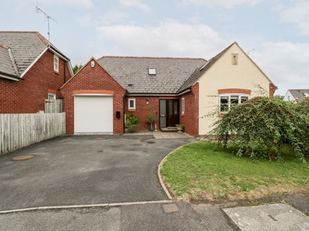 A single story house with a driveway garage and a front lawn at Hurst Green in Ewyas Harold near Hereford