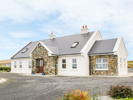 A stone and white exterior house with a gray roof and a gravel driveway at McGuire's Cottage Barnatra County Mayo