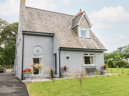 A detached house with a sloped roof and lawn in front at Pondfield Gate in Cwmgors
