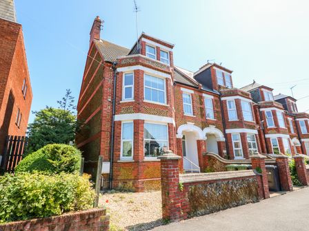 A row of brick terraced houses with bay windows and small front gardens at The Northgate Loft in Hunstanton