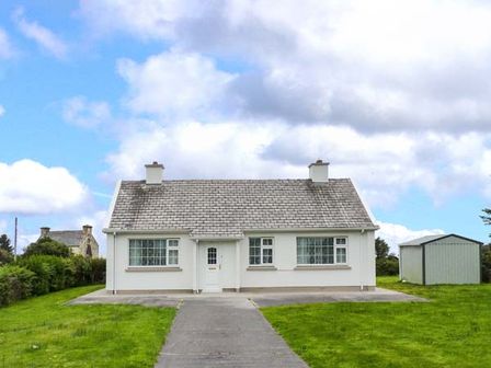 A single story house with two chimneys and a pathway leading to the front door at Ocean View in Ballinskelligs County Kerry