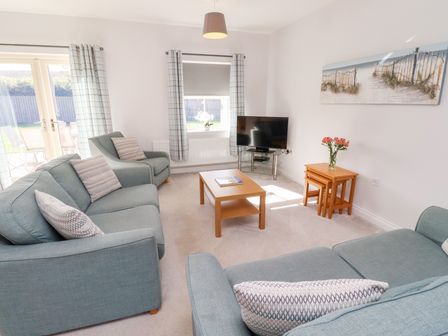 A living room with a television and seating area at The Haven in Embleton