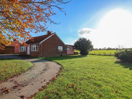 A house with a driveway and lawn at Glenhaven in Sweffling near Snape