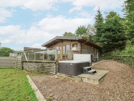 An outdoor area with a cabin and hot tub at The Cabin in Pontardawe