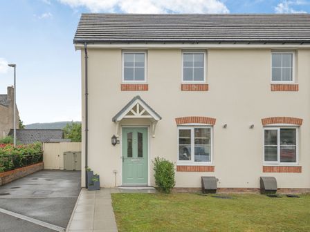 A front view of a modern semi detached house with a green door and pathway at Kymin View in Monmouth