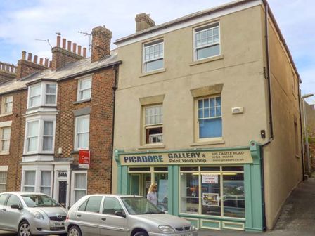 A street view showing a gallery and print workshop with two parked cars outside at Picadore in Scarborough
