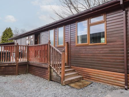 An exterior view of a wooden cabin with a small staircase and railing at 22 Thirlmere in Troutbeck Bridge