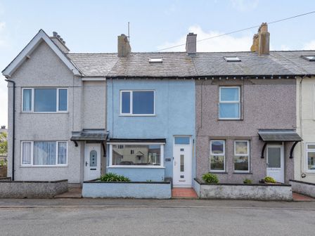 A row of terraced houses with different colored facades and small front gardens at 2 Tregof Terrace in Cemaes Bay