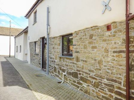 Exterior view of a house with stone and white walls on a paved driveway at Sunnymead Cottage Ashwater near Holsworthy