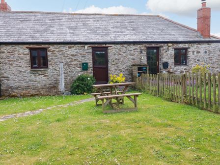 A cottage with a picnic table and garden at 4 Mowhay Cottages in Gorran Haven