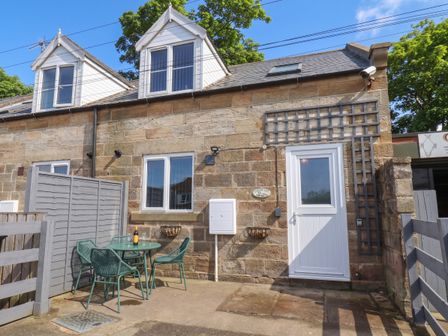 An outdoor seating area with a table and chairs at Fortunatus in Whitby