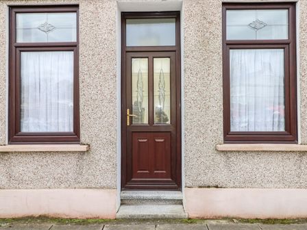 A front door with two windows on either side at Adeline in Pembrey