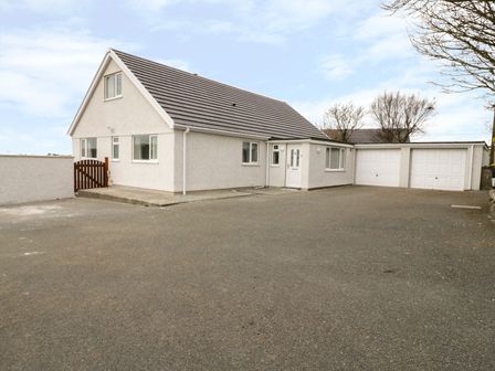A detached house with two garages and a paved driveway at Rhos Helyg in Penysarn near Amlwch