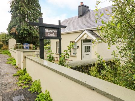 A small house with a sign reading Shandrum Brook and a concrete wall surrounding the property at Shandrum Brook in Charleville