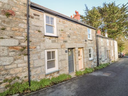 A stone cottage with two doors and four windows along a narrow street at Pippin in Lelant