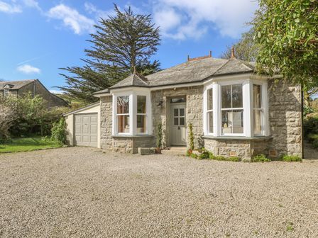 A stone house with two bay windows and a gravel driveway at Boskednan Wartha in Penzance