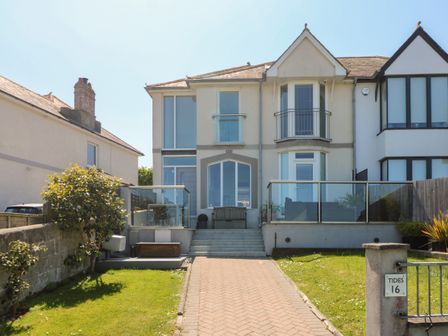 Front exterior of a two-story house with a paved driveway and glass railings at Tides in Padstow