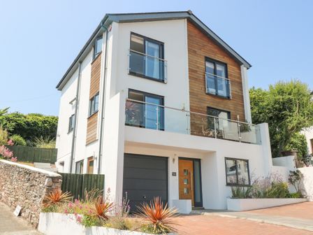 A modern three-story house with wooden accents and glass balconies at Lake View in Kingsand and Cawsand
