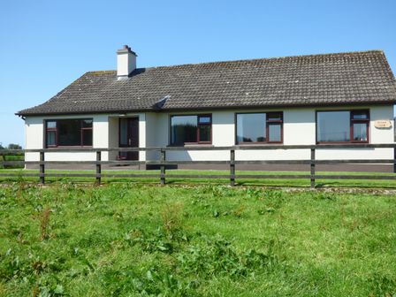 A single-story house with a fenced yard and grass in front of Nephin View in Foxford County Mayo