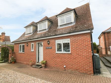 A brick house with a tiled roof and three dormer windows at The Lodge off High Street in Hadleigh