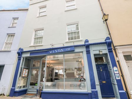 A cafe and restaurant storefront with blue accents and large windows at Vista in Tenby
