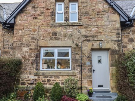Stone cottage exterior with windows door and garden at Rose Cottage in Lesbury near Alnmouth