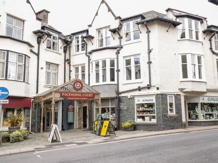 Exterior view of Packhorse Court shopping area with white buildings and storefronts in Keswick