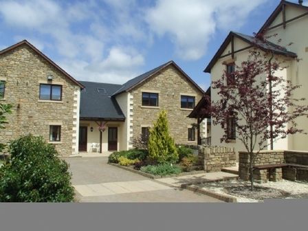 A courtyard with stone and plaster houses and landscaped garden at Whitbarrow Holiday Village Troutbeck 5 Ullswater