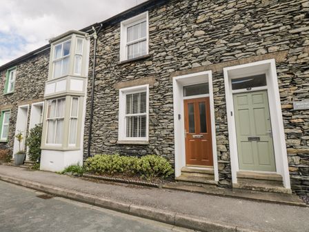 Stone exterior row houses with white framed windows and two front doors one wooden and one green at Beaumont Cottage