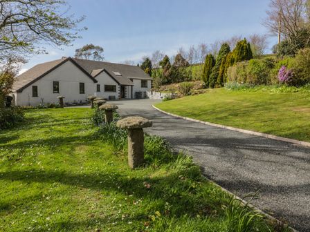 A driveway leading to a house surrounded by grass and trees at Higher Kernick Farm in Launceston