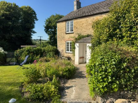 A garden view with a pathway and seating area at Kingbarth in Lerryn