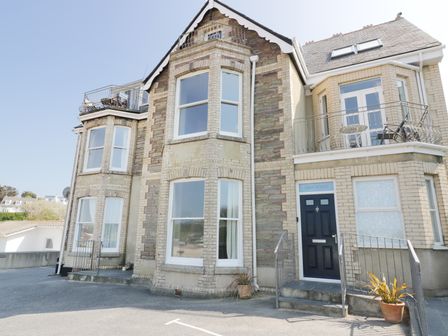 Exterior view of a two story house with large windows and balconies at Seashore House in Porth