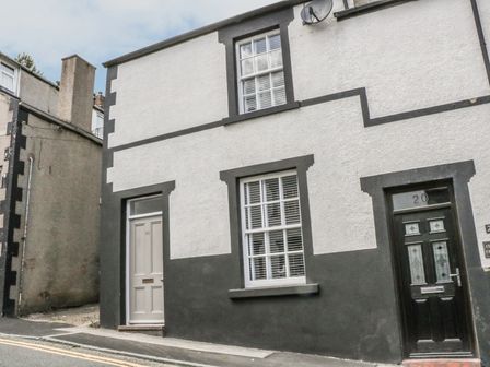 The exterior of a building with two doors and two windows on a street at 22 Uppergate Street in Conwy