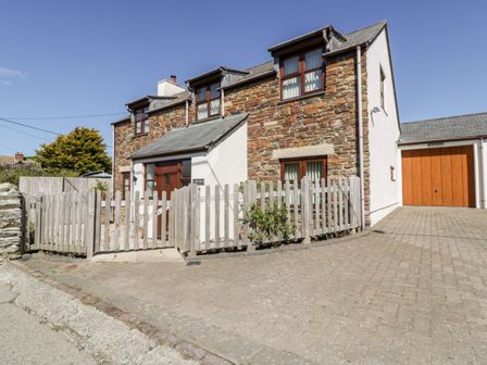 A stone and white house with wooden windows and a wooden gate with a driveway at Carpe Diem in Crantock