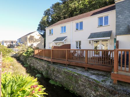 A row of houses with wooden decks next to a small canal at Fox's Walk in Falmouth