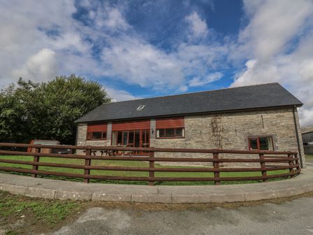 An exterior view of a house with a fenced area at Glanyrafon in St Harmon