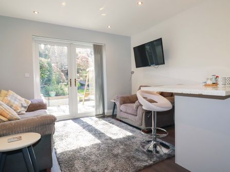 A living room with a sofa and tv at Little Pippin Carlyon Bay near St Austell